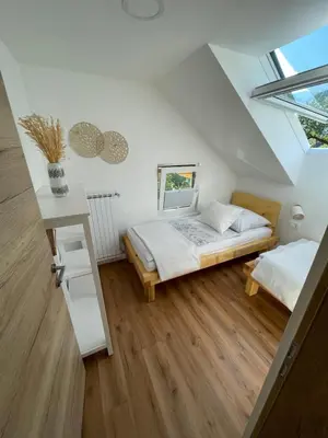 a attic bedroom with a bed and a table at Apartma Guide 360 in Bovec