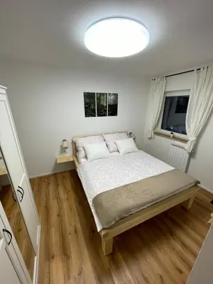 a small bedroom with a bed and a window at Apartma Guide 360 in Bovec
