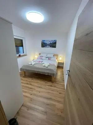 a bedroom with a bed in a room with a wooden floor at Apartma Guide 360 in Bovec