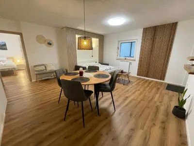 a dining room and living room with a table and chairs at Apartma Guide 360 in Bovec