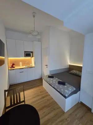 a small kitchen with a bed in the middle of a room at Delux apartment ARSO in Velenje