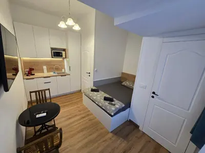 a living room with a couch and a kitchen at Delux apartment ARSO in Velenje