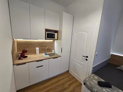 a small kitchen with white cabinets and a sink at Delux apartment ARSO in Velenje