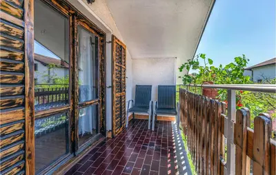 a balcony with a wooden fence and a chair at Stunning Apartment In Divaca With Wifi in Divača