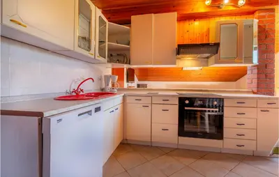 a kitchen with white cabinets and a red sink at Stunning Apartment In Divaca With Wifi in Divača