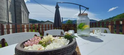a table with a vase of flowers and an umbrella at Apartma pr' Ivani Miškorinovi in Breginj