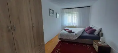 a small bedroom with a bed and a window at Apartma pr' Ivani Miškorinovi in Breginj