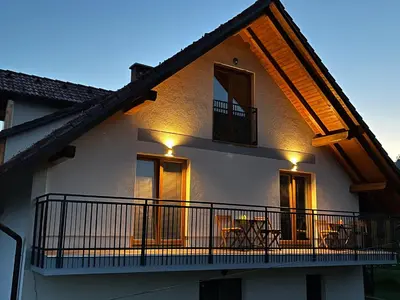 a house with a balcony with lights on it at Zemva Stays - Apartma ELA in Zgornje Gorje
