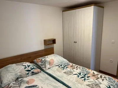 a bedroom with a bed and a closet at Zemva Stays - Apartma ELA in Zgornje Gorje