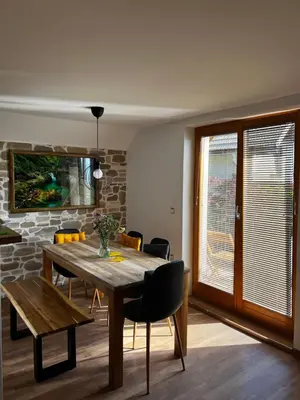 a dining room with a wooden table and chairs at Zemva Stays - Apartma ELA in Zgornje Gorje