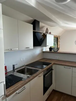a kitchen with white cabinets and a sink at Zemva Stays - Apartma ELA in Zgornje Gorje