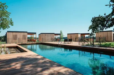 a swimming pool in front of a building with a playground at Wine paradise Glavinič in Miklavž pri Ormožu