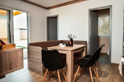 a dining room with a wooden table and black chairs at Wine paradise Glavinič in Miklavž pri Ormožu