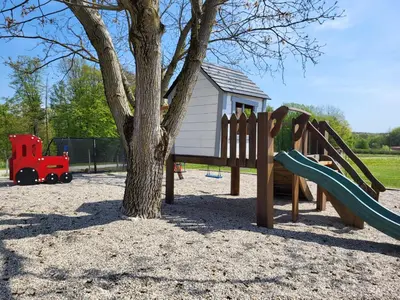 a playground with a tree and a slide at Wine paradise Glavinič in Miklavž pri Ormožu