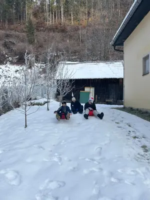 a group of three people sitting in the snow at Črjanski Raj in Črna na Koroškem