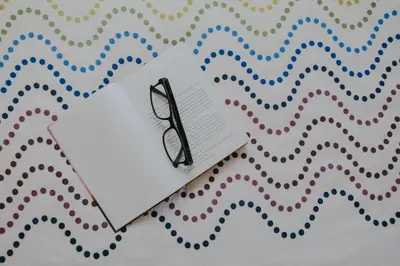 a pair of glasses sitting on top of a paper at Rooms Pri Lovrižu in Kobarid