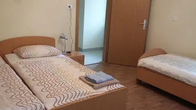 a bedroom with two beds and a door to another room at Rooms Pri Lovrižu in Kobarid