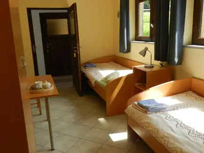 a room with two beds and a table with a lamp at Rooms Pri Lovrižu in Kobarid