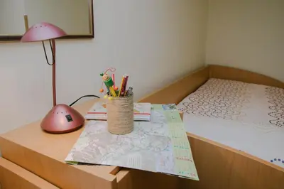 a bedroom with a bed and a desk with a table with a lamp at Rooms Pri Lovrižu in Kobarid