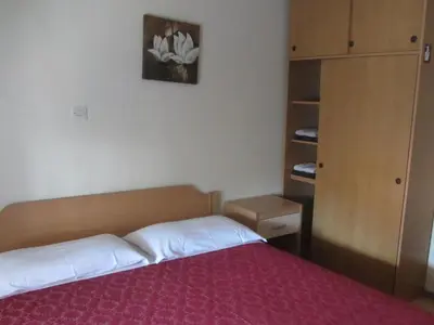a bedroom with a bed with a red bedspread at Rooms Pri Lovrižu in Kobarid
