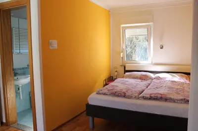 a bedroom with a bed and a sink and a window at Rooms Jurca in Postojna