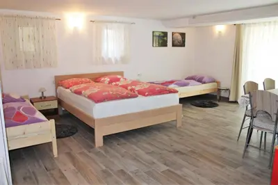 a bedroom with two beds and a table and chairs at Rooms Jurca in Postojna