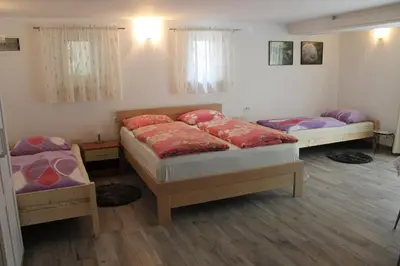 a bedroom with two beds and two tables at Rooms Jurca in Postojna
