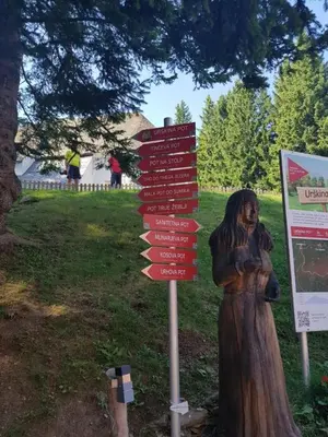 a statue of a woman standing next to a sign at Brunarica 6A - Pohorje - Trije Kralji - Druzinsko smucisce in Oplotnica