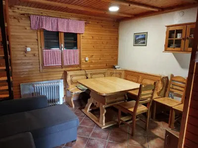 a dining room with a wooden table and chairs at Brunarica 6A - Pohorje - Trije Kralji - Druzinsko smucisce in Oplotnica