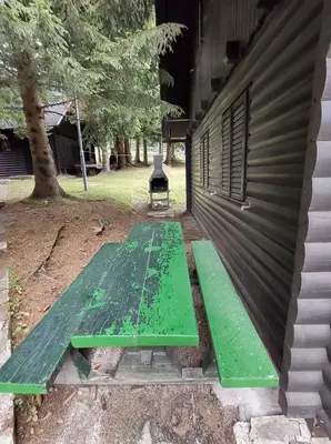 a green bench sitting outside of a building at Brunarica 6A - Pohorje - Trije Kralji - Druzinsko smucisce in Oplotnica