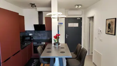 a kitchen with a table with a vase of flowers on it at Apartment Ozare in Slovenj Gradec