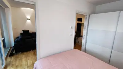 a bedroom with a bed and a black couch at Apartment Ozare in Slovenj Gradec