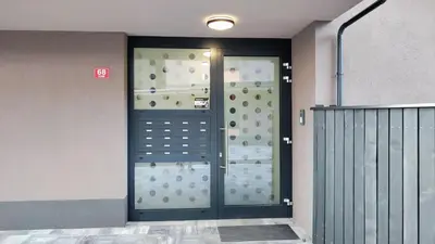 a front door of a building with a wall with a door at Apartment Ozare in Slovenj Gradec