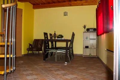 a dining room with a table and chairs at Počitniška hiška pod Hadikom in Lendava