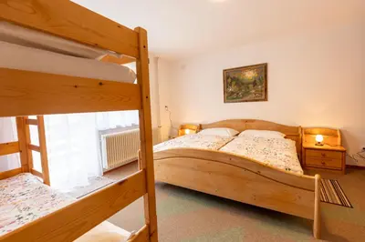 a bedroom with two bunk beds and a window at Apartmaji Arh Matilda in Bohinj