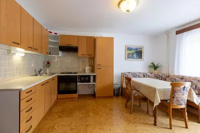 a small kitchen with a table and a couch at Apartmaji Arh Matilda in Bohinj