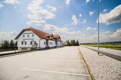a white building on the side of a road at Apartment Rimljanček in Leskovec pri Krškem
