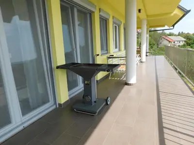 a grill on the side of a house on a balcony at Yellow House Grabrovec in Metlika