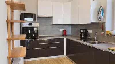a kitchen with white cabinets and stainless steel appliances at Yellow House Grabrovec in Metlika