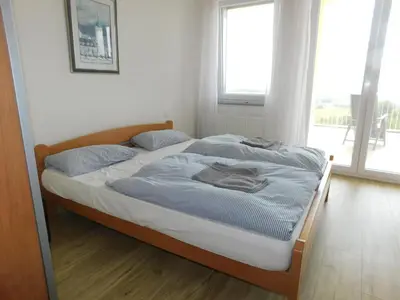 a bed in a room with a large window at Yellow House Grabrovec in Metlika