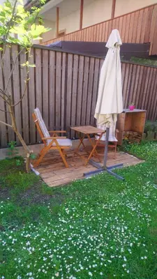 a patio with a table and an umbrella and a chair at Apartment Slovan in Škofja Loka