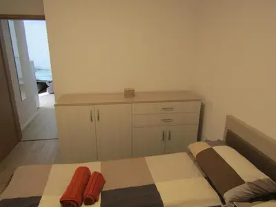 a bedroom with a bed and a dresser with towels at Apartma Melinc in Bovec