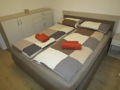 a bedroom with two beds with orange pillows on them at Apartma Melinc in Bovec