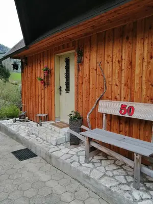 a wooden house with a bench in front of it at Hiša pod Rogatcem in Luče