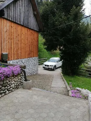 a white car parked in a driveway next to a building at Hiša pod Rogatcem in Luče