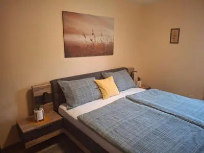 a bedroom with a bed with blue and yellow pillows at Apartment Veninsek in Luče