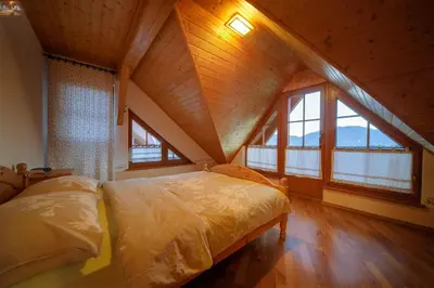 a bedroom with a large bed in a attic at Apartmaji Pri Handelčanih, Zreče in Zreče