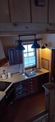 a kitchen with two lights hanging over a sink at Apartmaji Pri Handelčanih, Zreče in Zreče