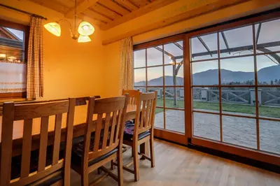 a dining room with a table and chairs and windows at Apartmaji Pri Handelčanih, Zreče in Zreče