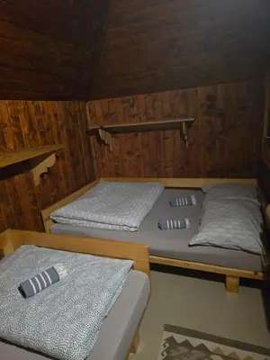 a room with two beds in a cabin at Koča Pastirica - Velika planina in Stahovica